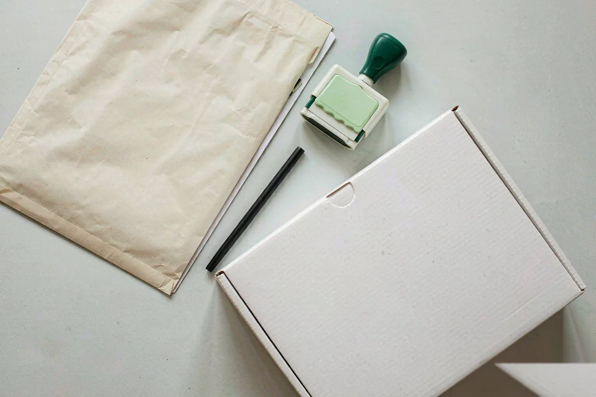 Compliance dossier documents with stamp, clipboard and shipping box that vape wholesale buyers should request from suppl