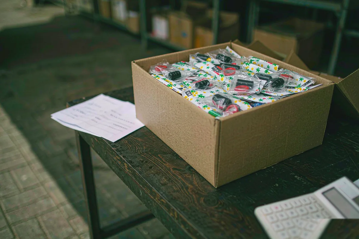 Shipping carton, invoice and calculator on a desk, showing the hidden TPD compliance cost per carton of vape stock